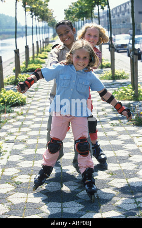 Three kids on roller skates Stock Photo