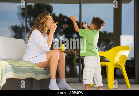Woman and boy blowing bubbles Stock Photo