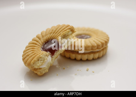 Two Jam Sandwich biscuits on a white plate Stock Photo