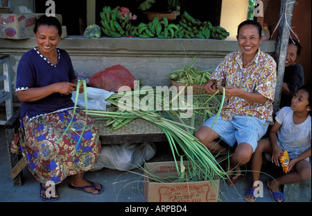 Making plaited baskets from palm leave used to carry offerings in temples and shrines Jungubatu Lembongan Is Bali Indonesia Stock Photo