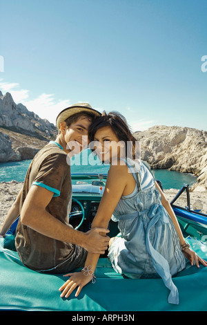 Man and woman sitting on car Stock Photo