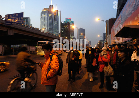 People waiting at bus stop in Guomao area, CBD of Beijing, China. 15-Feb-2008