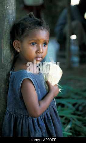 AFRICA KENYA KALIFI Young Kenyan girl eating coconut in her family s barn Stock Photo