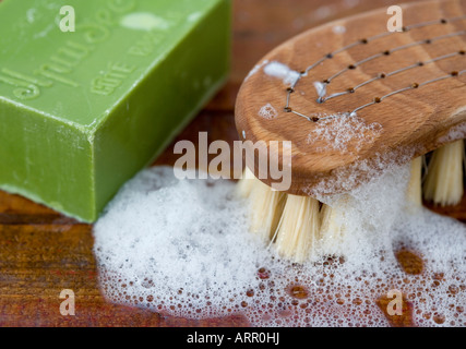 Bar of household soap with a traditional wooden scrubbing brush Stock Photo