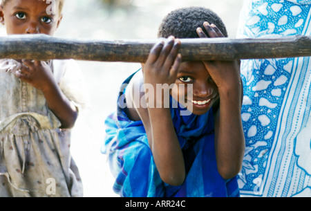 AFRICA KENYA KALIFI Young Kenyan girls play peek a boo with visitors as their mother stands by dressed in traditional kanga c Stock Photo