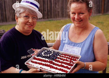 Sisters holding an American flag cake the 4th of July Independence Day Snohomish County, Washington State USA Stock Photo