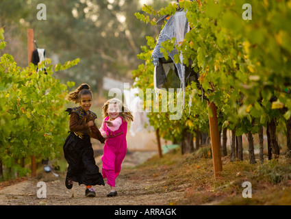 two young girls running in costume through the wine vineyards of the Longshadow Ranch and Winery in Temecula, California Stock Photo