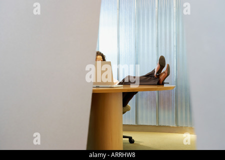 Woman with her feet up on desk Stock Photo