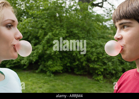 Teenage couple blowing bubble gum bubbles Stock Photo