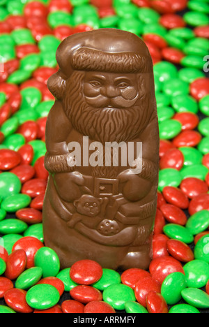 A chocolate Santa Clause lies in a pool of green and red candied chocolate Stock Photo