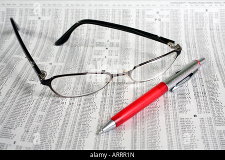 Eyeglasses and pen on newspaper financial page Stock Photo