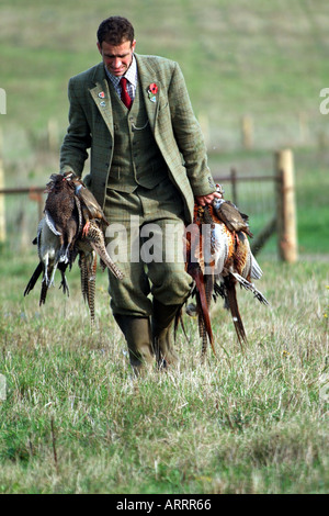 gamekeeper with bag of the day braces of  pheasants English rural scene