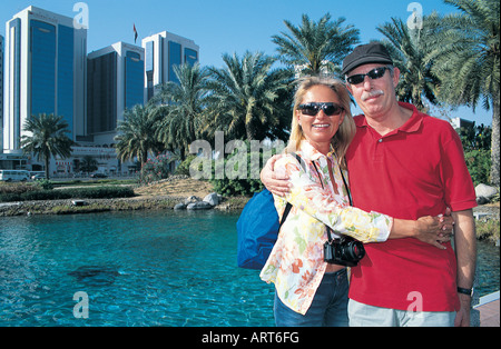 Western tourist couple at a pond near Emirates Towers, Dubai, United Arab Emirates Stock Photo