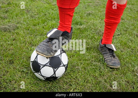 Footballer standing on football Stock Photo