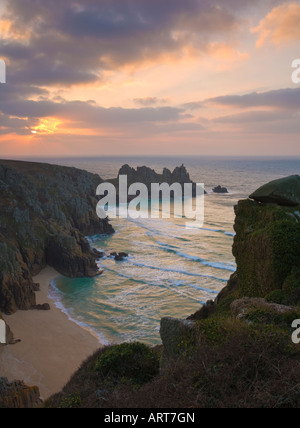 Vibrant sunrise on Treen Cliffs near Porthcurno Cornwall with Pendnvounder beach in the foreground Stock Photo