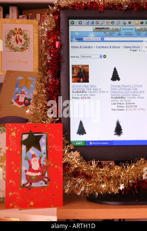 A computer screen decorated with tinsel displaying a Christmas-themed page from the Amazon web site with Christmas cards. 2005. Stock Photo