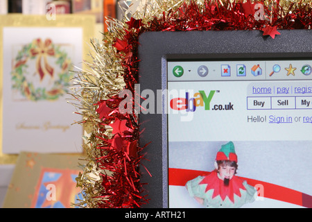 A computer screen decorated with tinsel displaying a Christmas-themed page from the ebay web site. 2005 Stock Photo