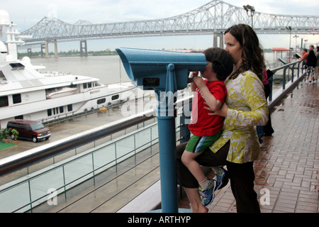 Mother helping son view the sites through binoculars, New Orleans, LA, USA Stock Photo