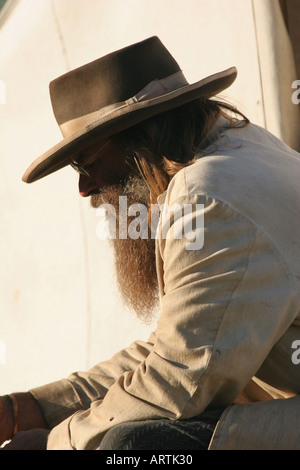 Cowboy reenactor sitting down in front of a tent at a Buffalo Bill Wild West reenactment in Wisconsin Stock Photo