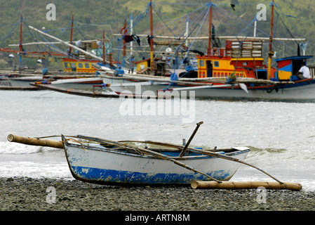 A small outrigger boat sits on the beach in Mansalay, Oriental Mindoro, Philippines. Stock Photo