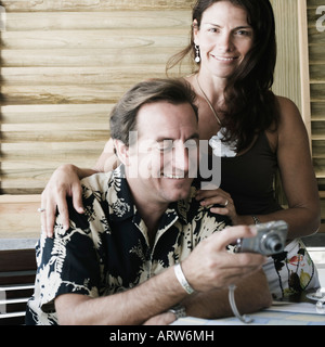 Mid adult man holding a digital camera with a mid adult woman standing beside him Stock Photo