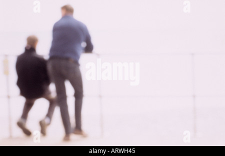 Impressionistic figures possibly father and teenage son leaning on railings Stock Photo