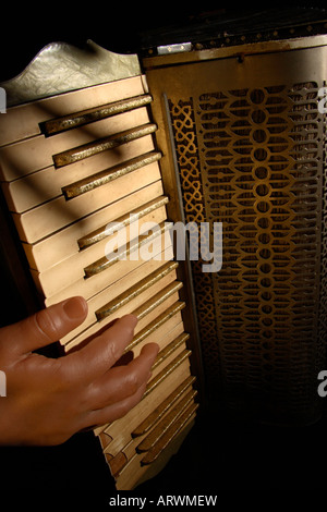 A spooky false hand plays an old broken Accordion. Stock Photo