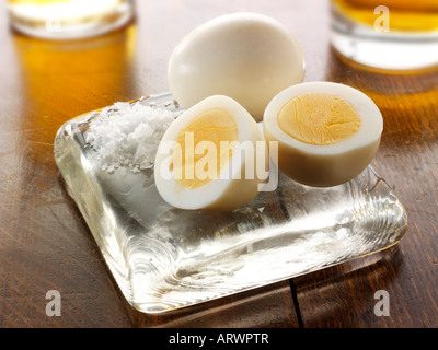 Traditional British preserved pickled eggs pub food on a traditional  wood pub table ready to eat Stock Photo