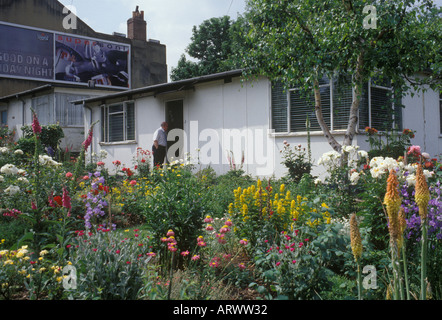 Lewisham South London UK. Uni Seco type prefab, built 1945 - 1949 temporary housing Photographed 1990s. Owner at door garden Stock Photo