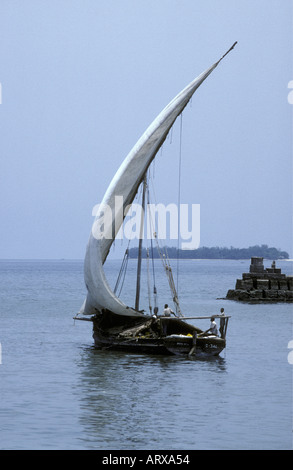 A traditional sailing boat or jahazi leaving the harbour of the stone town Zanzibar Tanzania East Africa Stock Photo