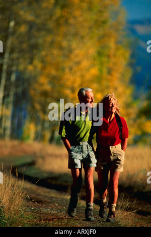 Senior couple walking down road in autumn colors Stock Photo