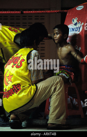 A young Thai boxer sitting in the corner of the ring during the fight break Koh Yao Noi southern Thailand 2005 Stock Photo