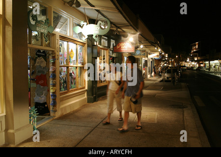 Shoppers head out into evening to enjoy stores, art galleries & restaurants along Front street historic downtown Lahiana, Maui Stock Photo