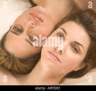 Two women lying cheek to cheek Stock Photo