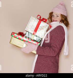 Woman carrying pile of presents Stock Photo