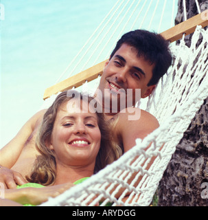 Young couple in hammock near beach Stock Photo