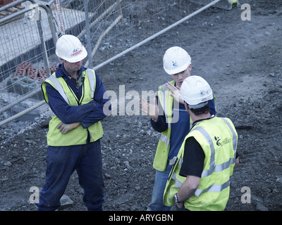 Three workmen on site, having a discussion. Stock Photo