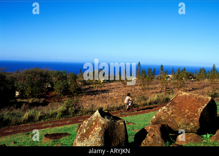 Bicyclists riding in Paniolo Camp with the Tentalow's in the background on Molokai Ranch Stock Photo