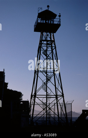 Guards watch tower on Alcatraz silhouetted against a clear blue evening sky, mist over the harbour water in the background Stock Photo