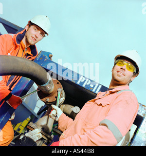 Construction workers adjusting pipe Stock Photo