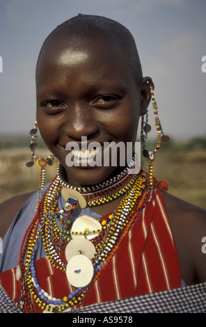 Vertical format close up portrait of a young Maasai woman wearing traditional bead necklaces and ear ornaments Stock Photo