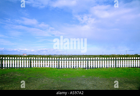 White wooden fence with blue sky in Dungeness Kent England UK Stock Photo