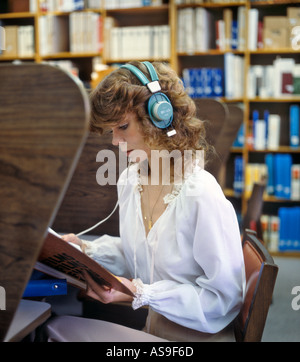 young woman working in library with aid of headset Stock Photo