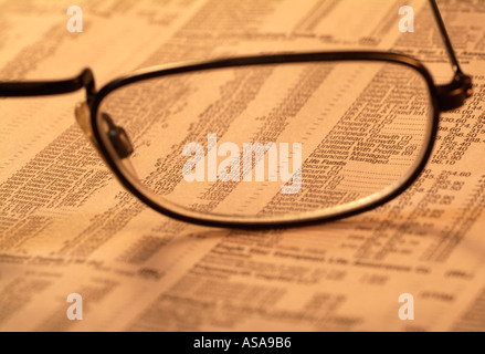 Spectacles on Top of the Financial Pages of a Newspaper Stock Photo