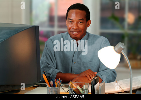 Black man working at his computer in a home office Stock Photo