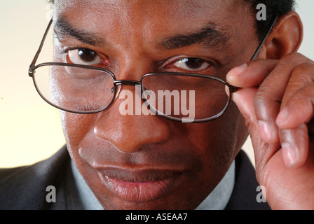Black executive looks over his glasses disapprovingly Stock Photo