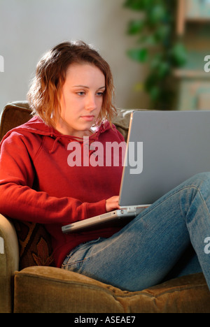 18 year old woman working on a laptop on the couch Stock Photo