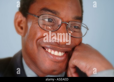 A black businessman wearing glasses smiling in a portrait Stock Photo