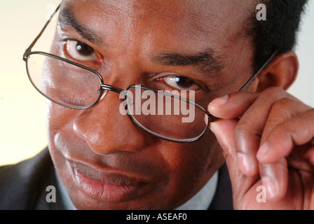 A black executive looks over the rim of his glasses disapprovingly. Stock Photo