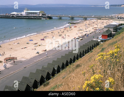 Bournemouth seaside holiday resort with beach huts and sandy shore line with pier beyond Stock Photo
